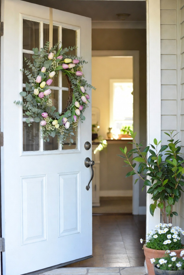 Spring floral wreath on a white front door creating a welcoming entryway.