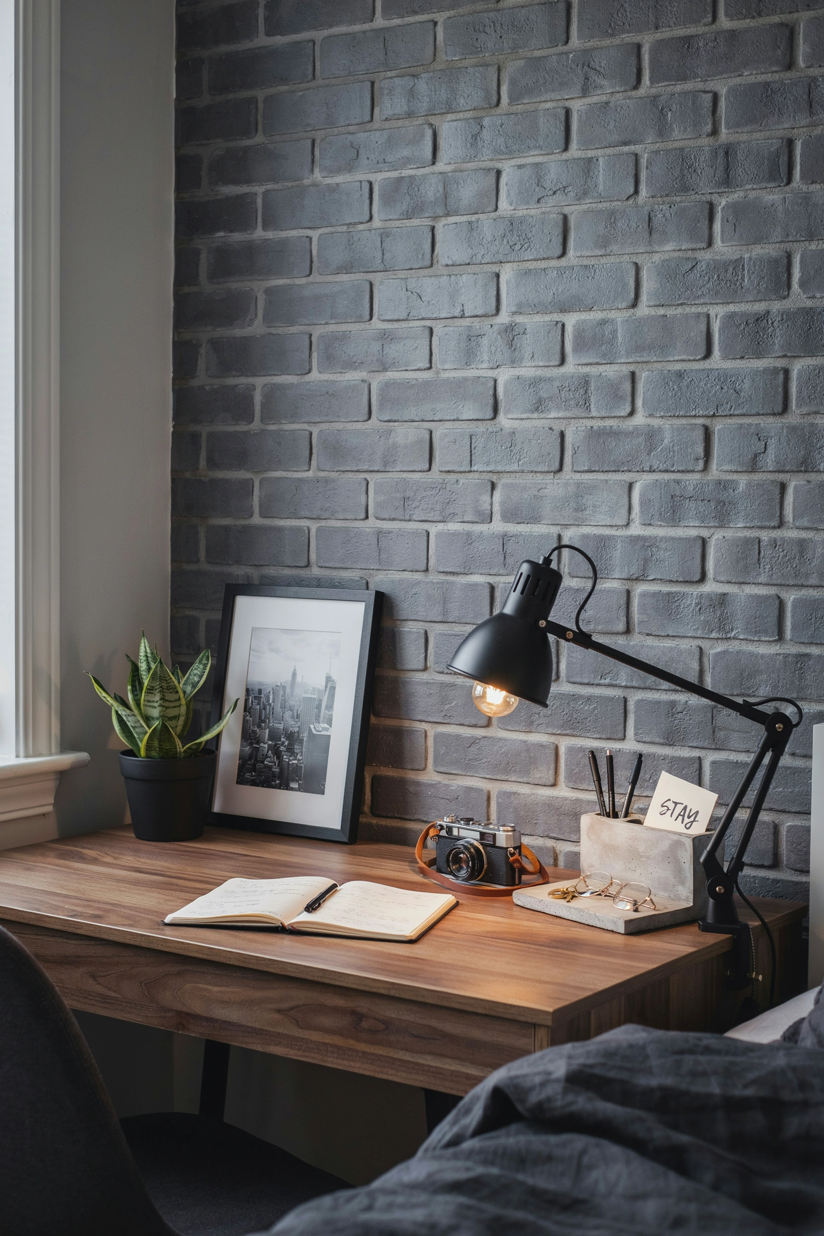 Industrial college bedroom with faux brick wall, black metal lamp, and concrete accessories for men