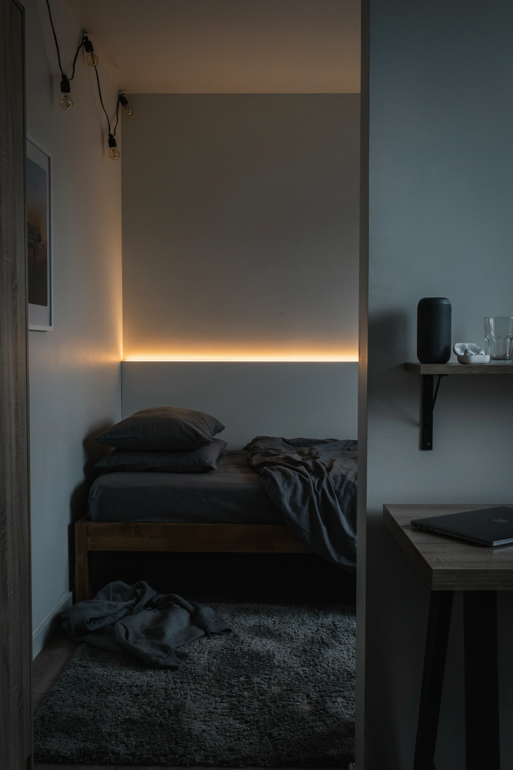 Cozy college bedroom with amber LED lighting behind bed frame — dorm room lighting ideas for men
