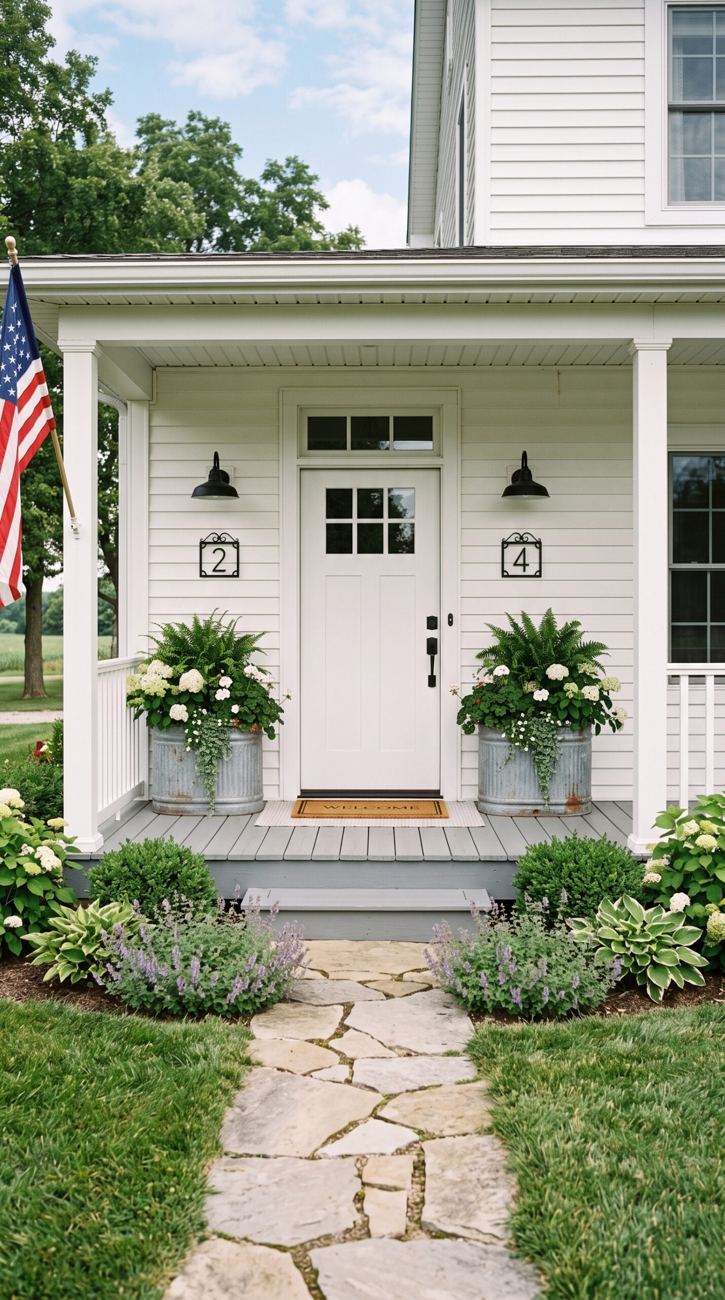 Symmetrical farmhouse front porch entry with matching planters and house numbers